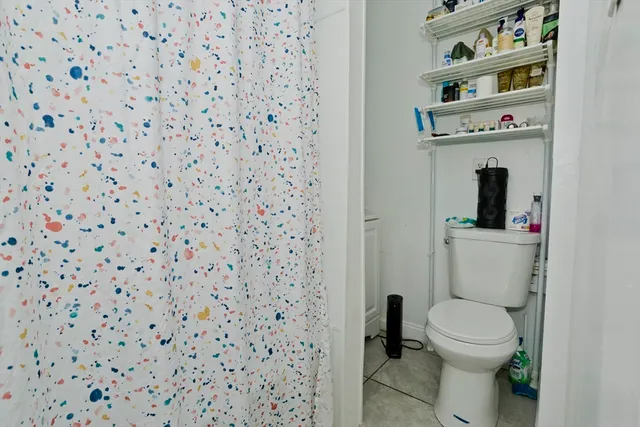 a bathroom with a toilet and a shower curtain