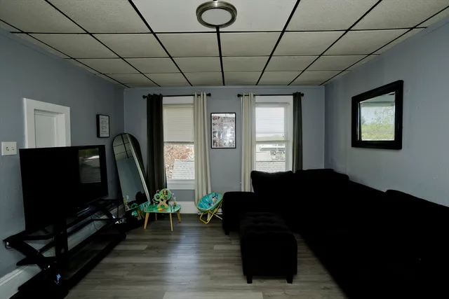 a living room with furniture a flat screen tv and a window