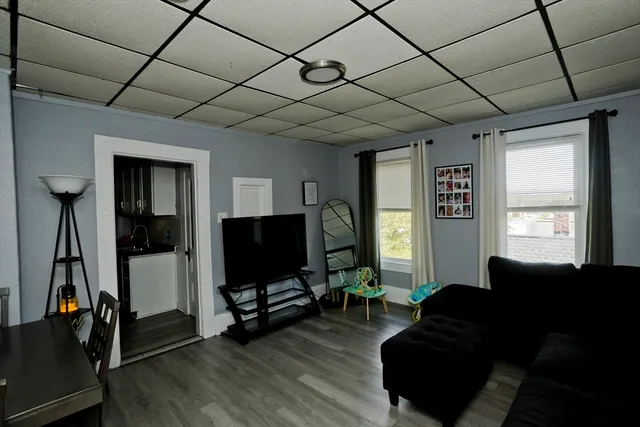 a living room with furniture a window and a flat screen tv