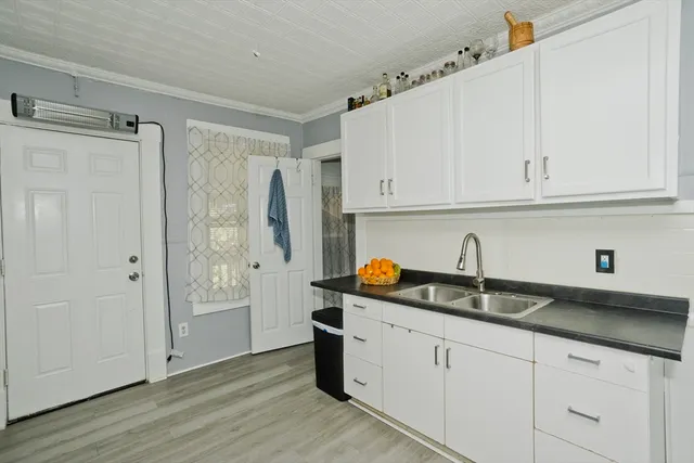a kitchen with stainless steel appliances granite countertop white cabinets and a sink