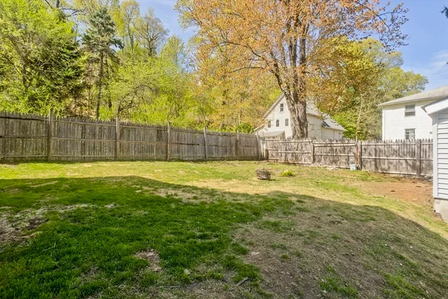a view of swimming pool with large trees and wooden fence