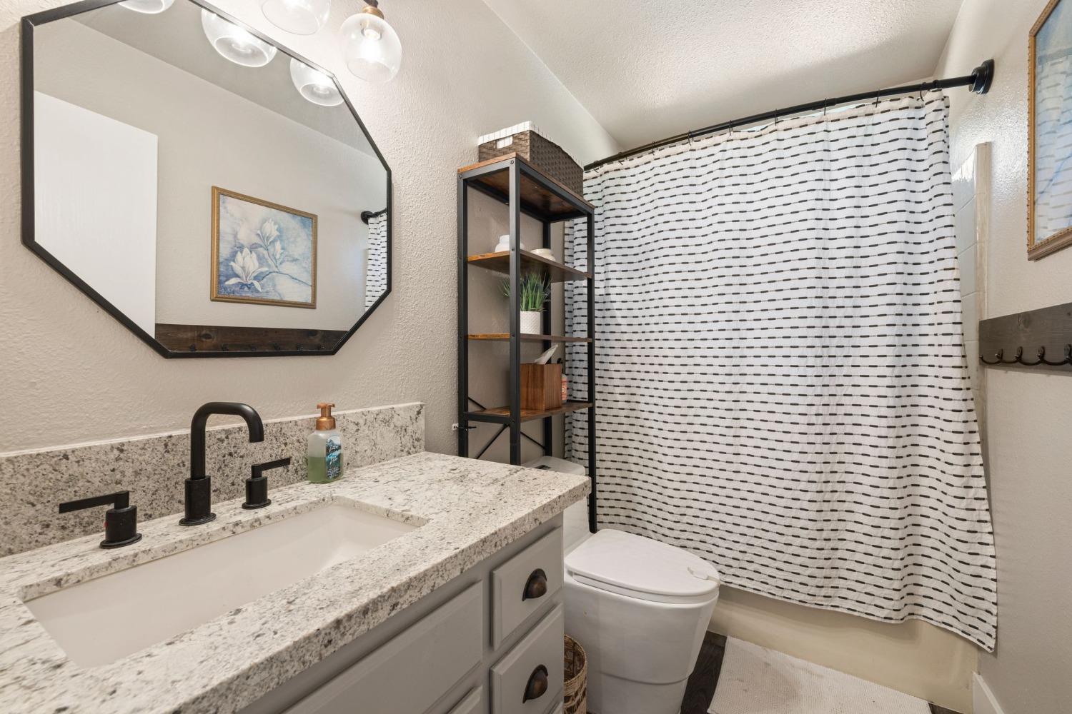 4842 Northern Lights Road Placerville, CA 95667 - Photo 21 of 26 a bathroom with a granite countertop toilet a sink and mirror