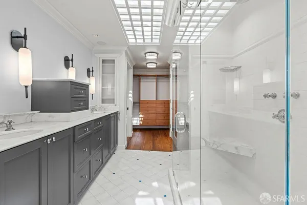 a bedroom with a bed and a lamp on dresser next to a window