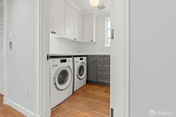 a view of an empty room with wooden floor fireplace and a window