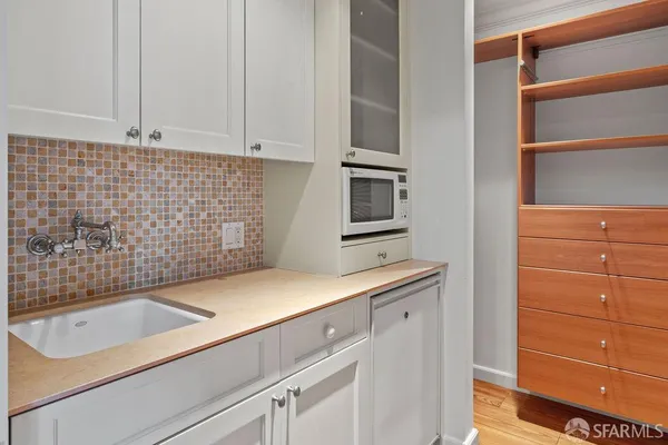 a open kitchen with stainless steel appliances granite countertop a refrigerator a sink dishwasher a dining table and chairs with wooden floor