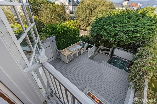 a view of a wooden deck and a yard with car parked