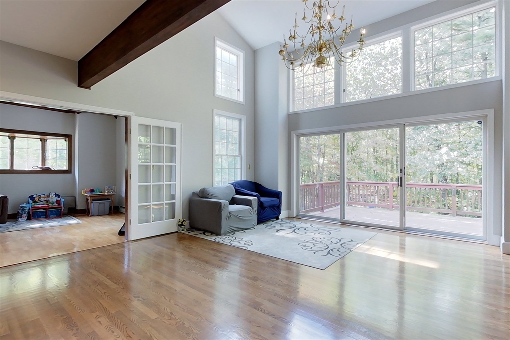 55 Gilchrist Road Townsend, MA 01469 - Photo 13 of 42 a spacious bedroom with a balcony a bed and a chandelier