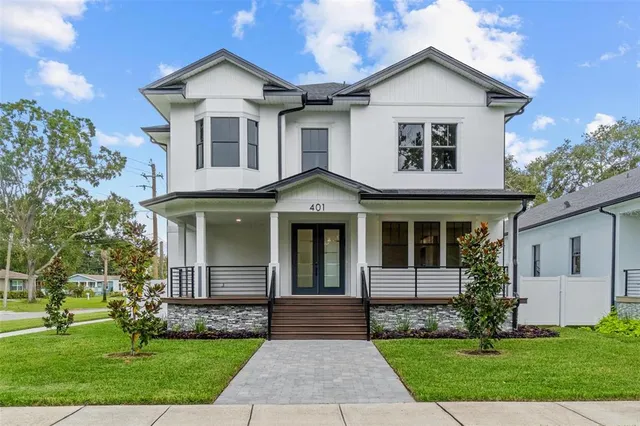 a front view of a house with a yard and trees