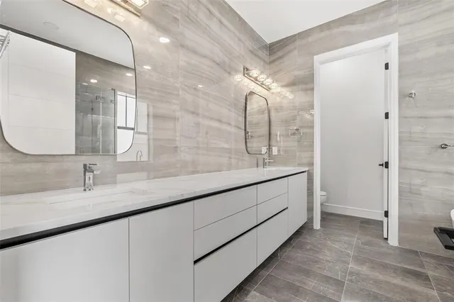 a bathroom with a double vanity sink mirror and shower
