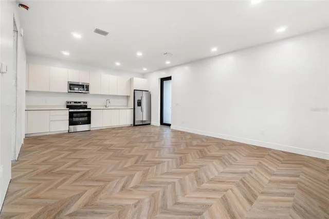 a view of a kitchen with a sink and a refrigerator