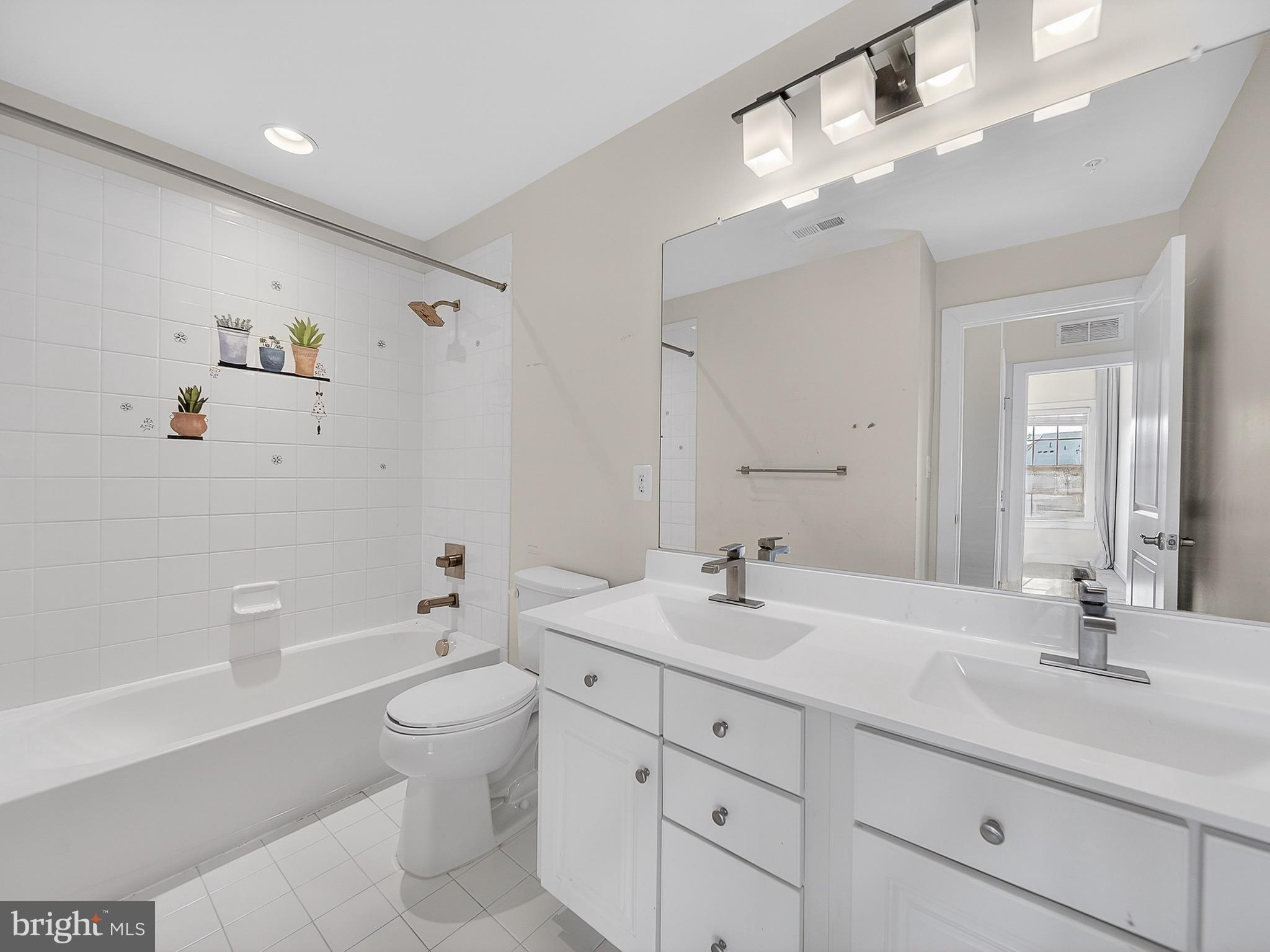 2914 Middleham Court Hanover, MD 21076 - Photo 25 of 50 a bathroom with a double vanity sink toilet mirror and bathtub