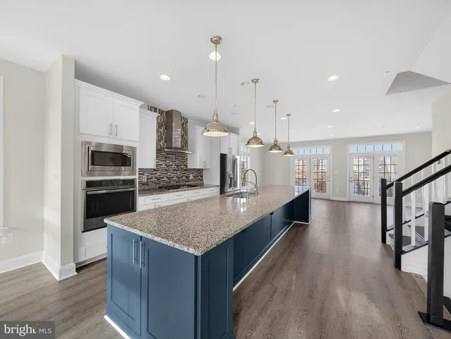 a large kitchen with stainless steel appliances kitchen island granite countertop a large counter top and stove top oven