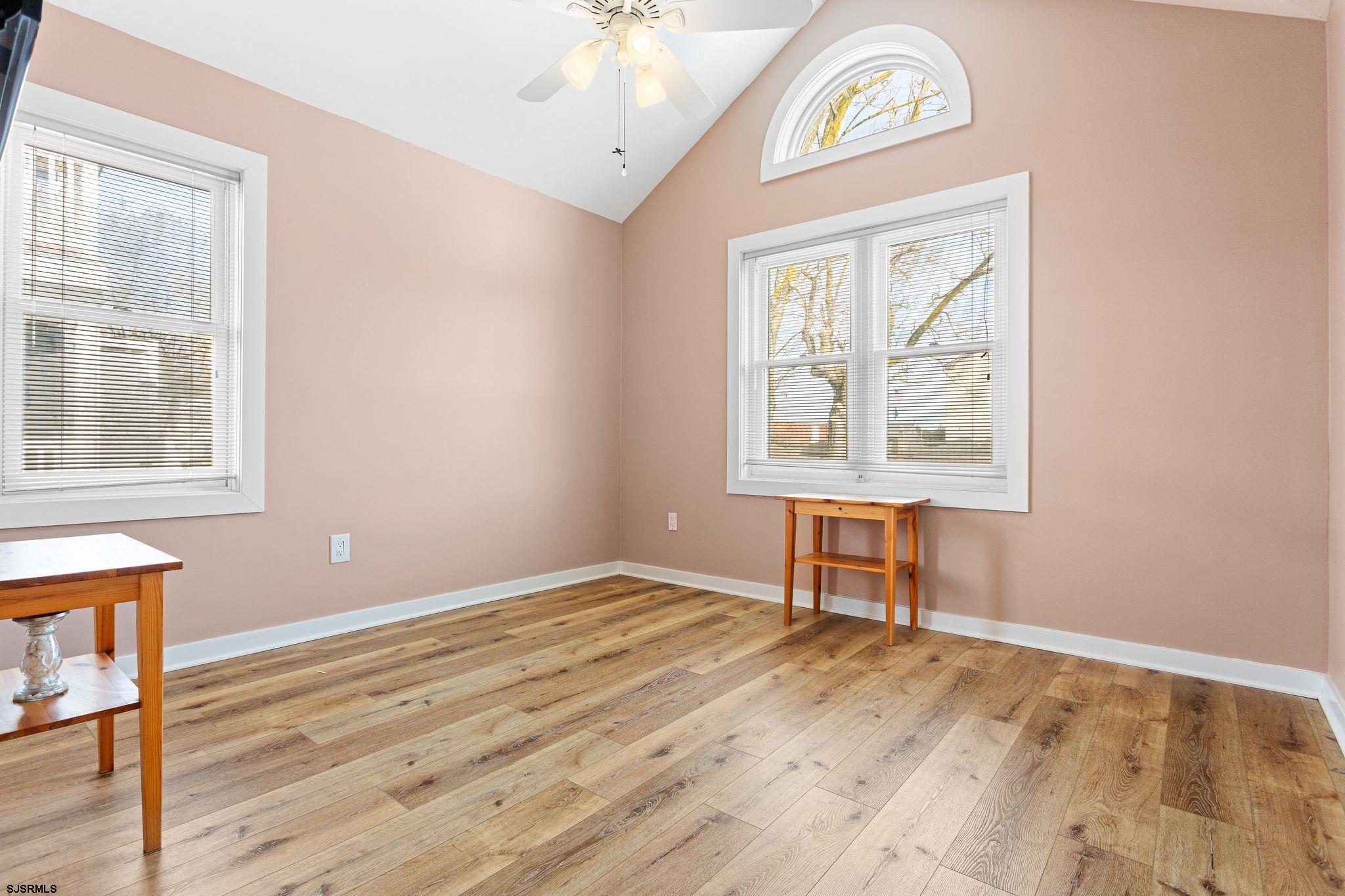 701 Lighthouse Road Cape May Point, NJ 08212 - Photo 12 of 32 an empty room with wooden floor a ceiling fan and windows