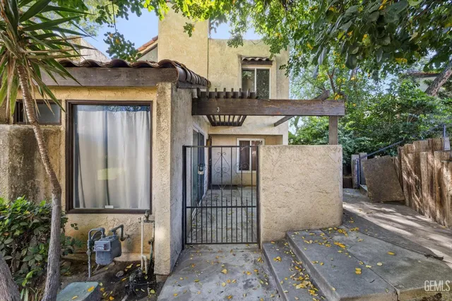 a front view of a house with a tree