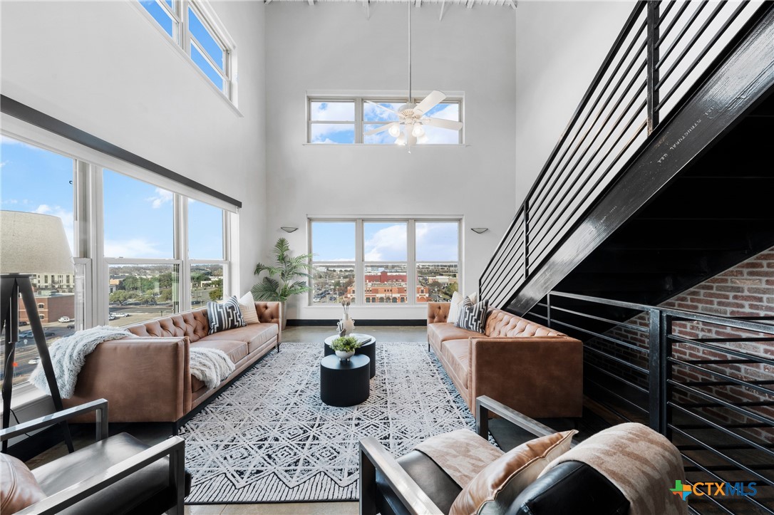 a living room with furniture fireplace and a large window