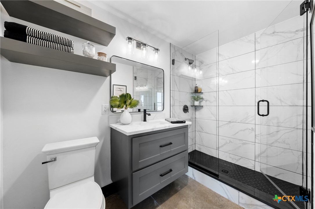 219 South 4th Street, Unit 608 Waco, TX 76701 - Photo 14 of 42 a bathroom with a granite countertop sink a toilet and shower