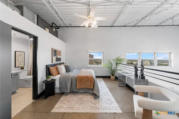 a spacious bedroom with a bed and a chandelier