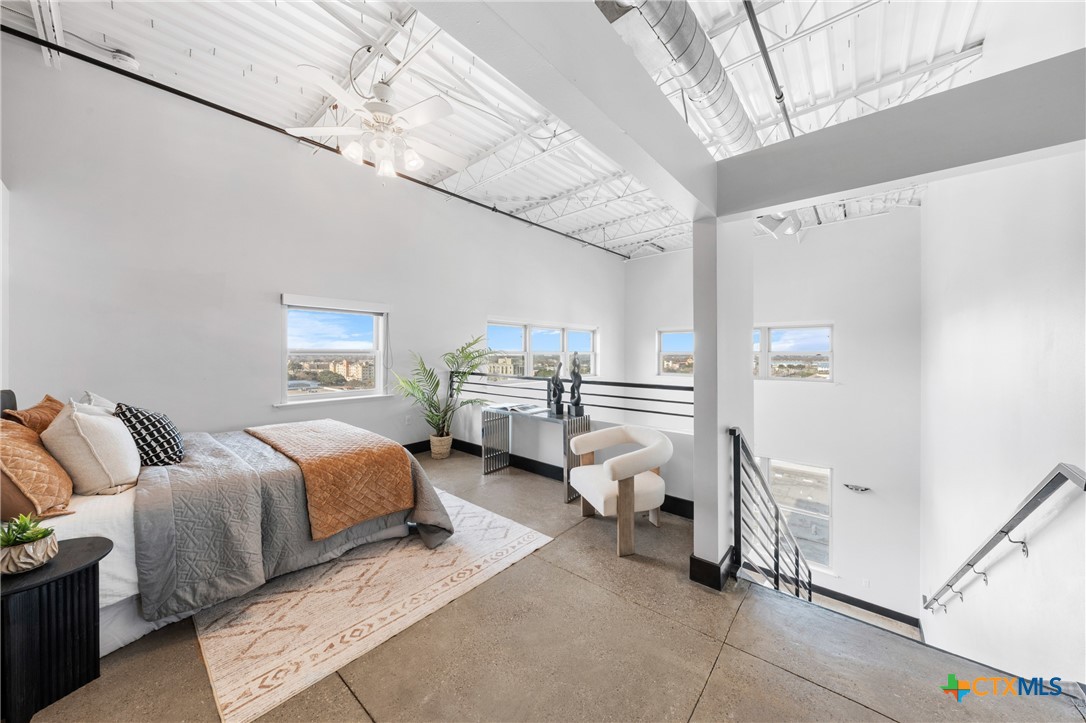 219 South 4th Street, Unit 608 Waco, TX 76701 - Photo 19 of 42 a spacious bedroom with a bed and a chandelier