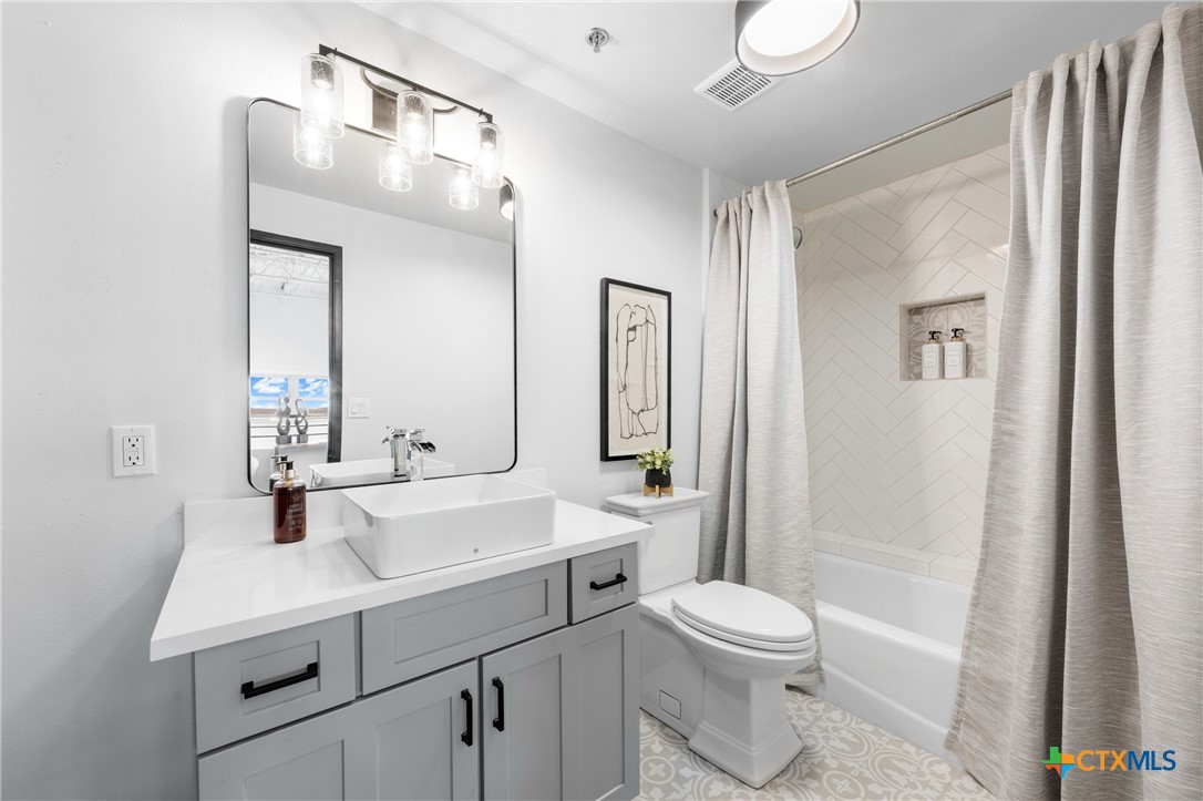 219 South 4th Street, Unit 608 Waco, TX 76701 - Photo 22 of 42 a bathroom with a sink a toilet a mirror and shower