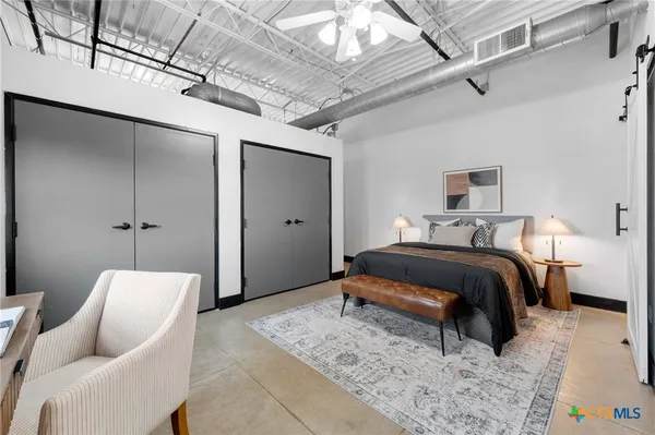 a living room with stainless steel appliances furniture a chandelier and a view of kitchen
