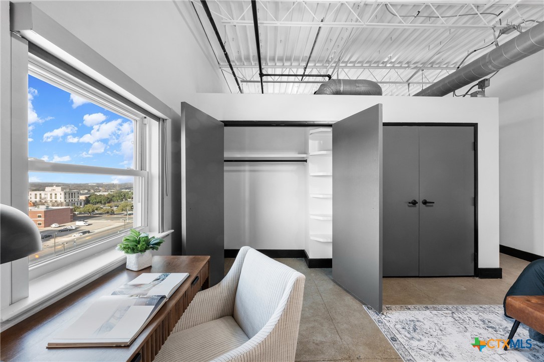 219 South 4th Street, Unit 608 Waco, TX 76701 - Photo 26 of 42 a living room with stainless steel appliances furniture a chandelier and a view of kitchen
