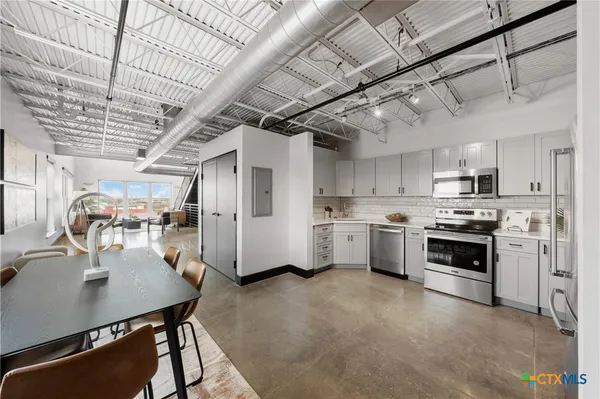 a kitchen with white cabinets and white appliances