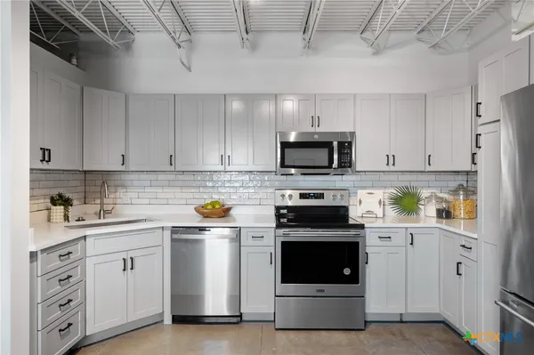 a kitchen with refrigerator and microwave