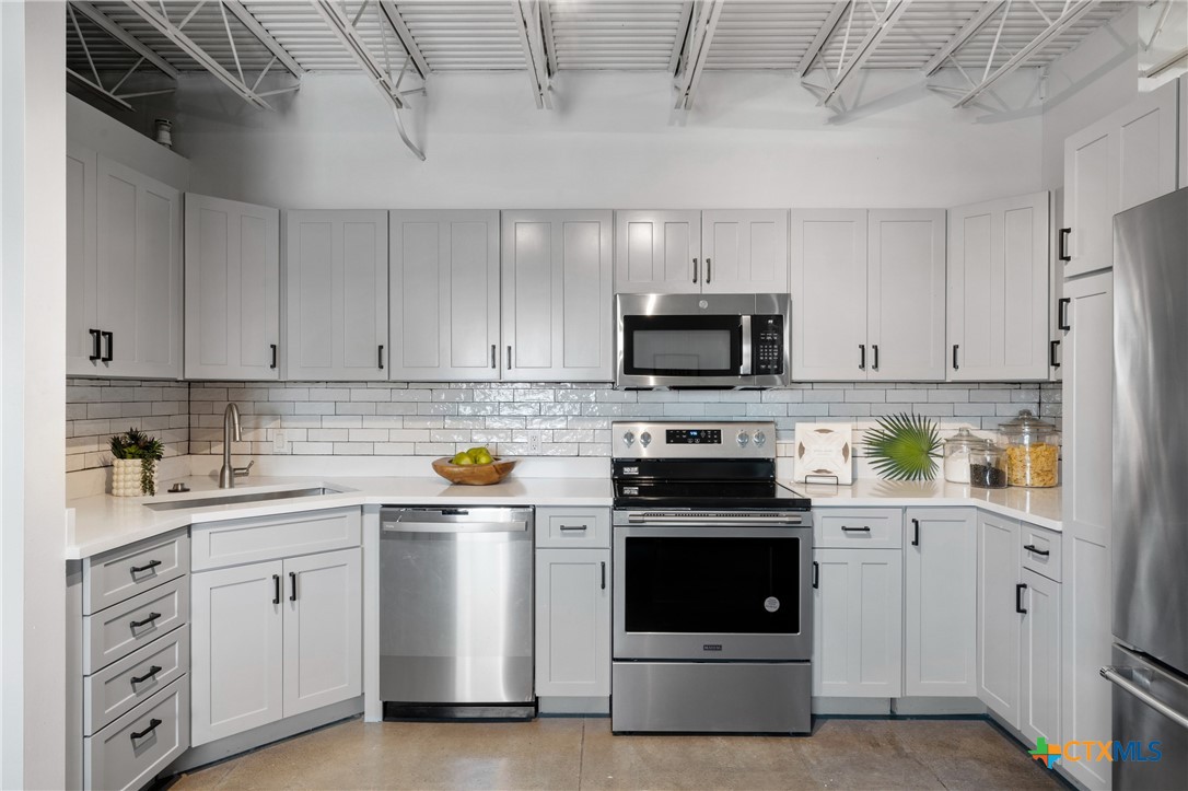 219 South 4th Street, Unit 608 Waco, TX 76701 - Photo 8 of 42 a kitchen with white cabinets and white appliances
