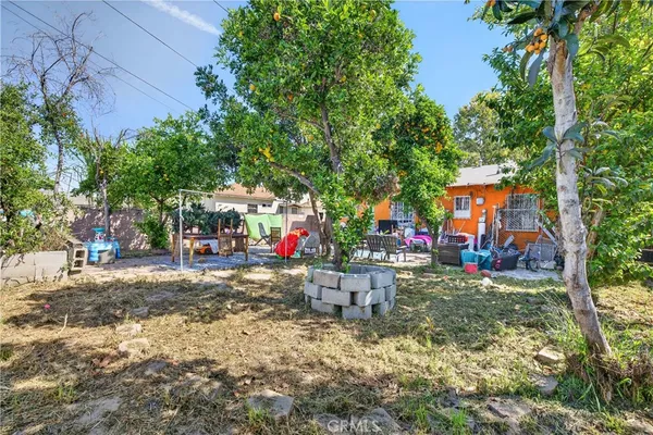 a view of a patio with table and chairs potted plants and large tree