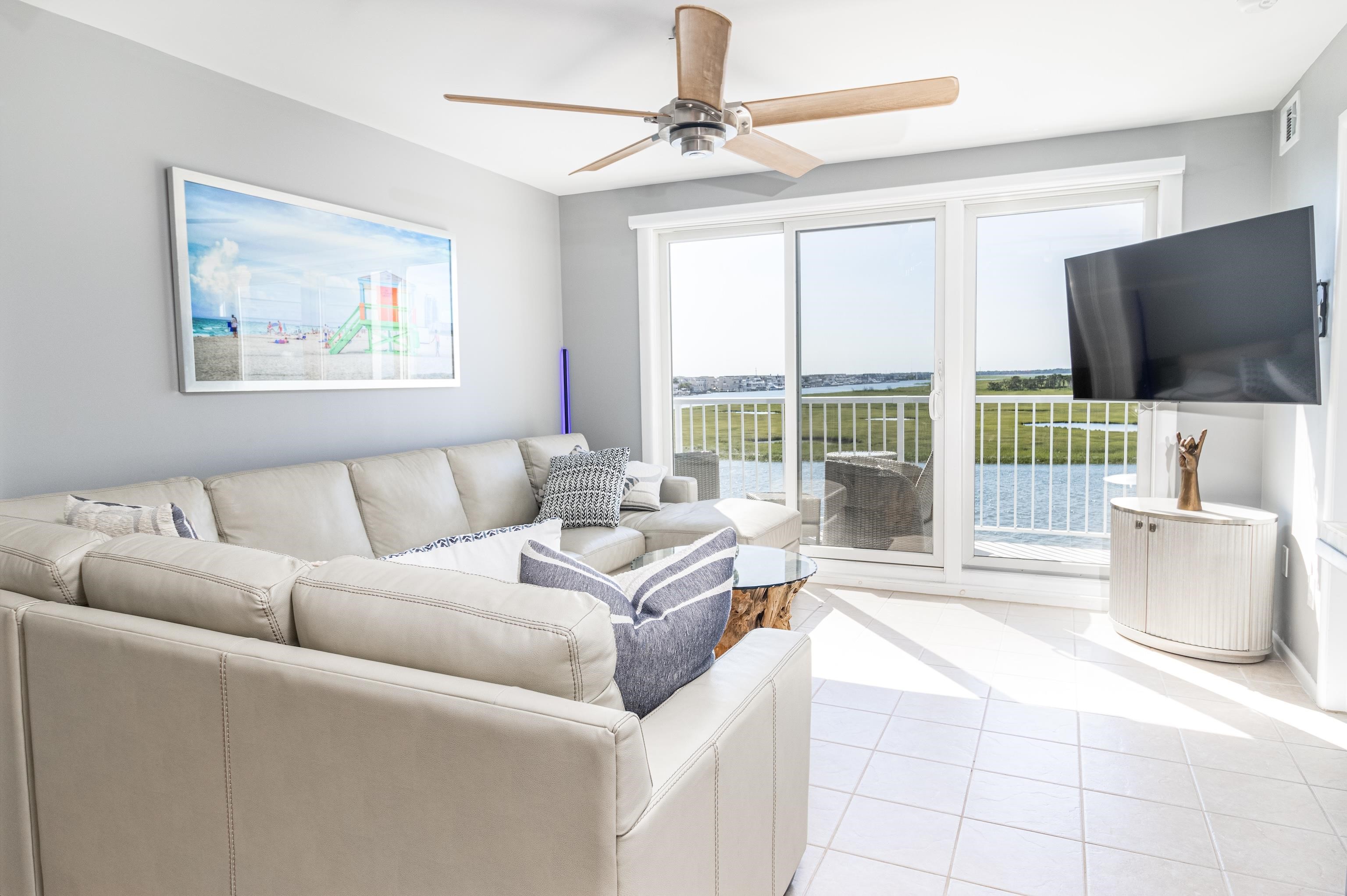 1708 Ocean Drive, Unit 6 Avalon, NJ 08202 - Photo 3 of 18 a living room with furniture a flat screen tv and a floor to ceiling window