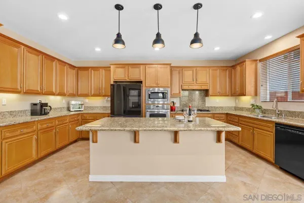 a kitchen with stainless steel appliances granite countertop a sink a stove and a refrigerator