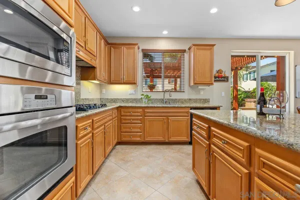 a kitchen with stainless steel appliances granite countertop a stove a sink and a microwave