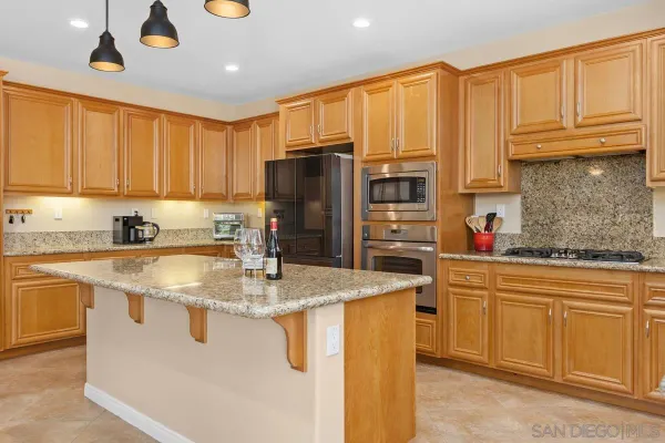a kitchen with stainless steel appliances granite countertop a sink a stove and refrigerator