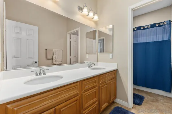 a bathroom with a granite countertop sink a mirror and a shower
