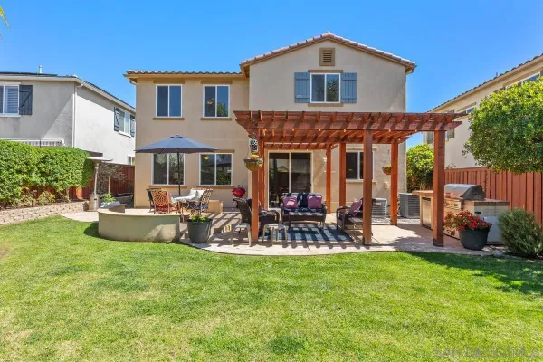 a view of a house with a patio and a yard