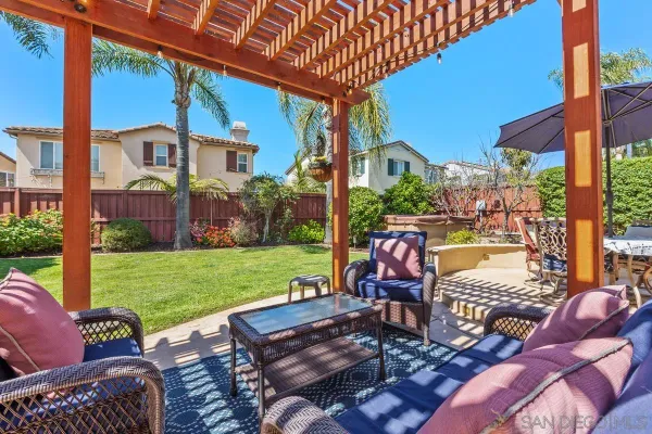 a view of a patio with table and chairs potted plants and palm trees