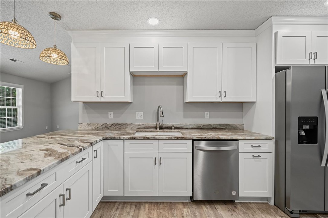 212 Blue Ridge Drive Clemson, SC 29631 - Photo 8 of 33 White cabinetry with stone counters and stainless steel appliances define this modern culinary space.