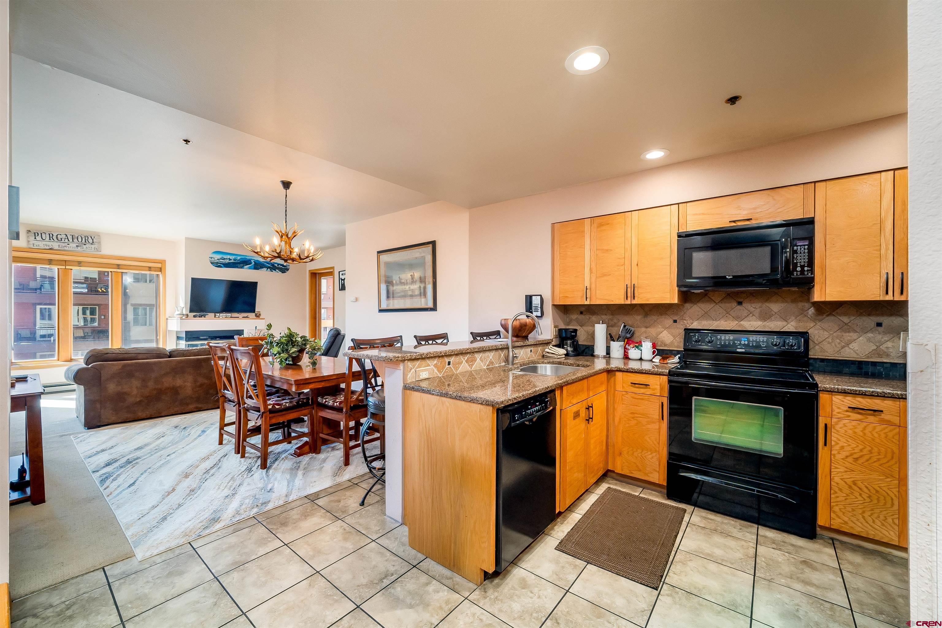 71 East Needles Road, Unit 337 Durango, CO 81301 - Photo 2 of 45 a kitchen with stainless steel appliances granite countertop a stove top oven a sink dishwasher a dining table and chairs with wooden floor