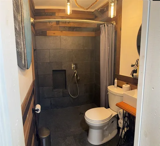 a bathroom with a toilet and a shower