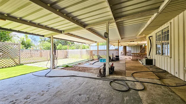 a view of a patio with table and chairs and couches with wooden floor and fence