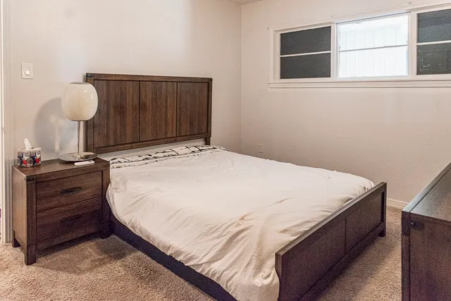 a bed sitting in a bedroom and wooden floor