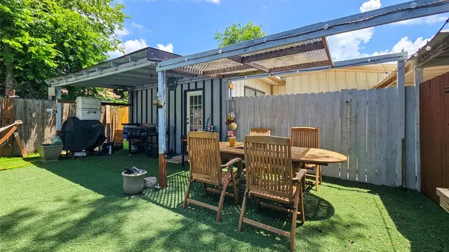 a view of a backyard with table and chairs and potted plants