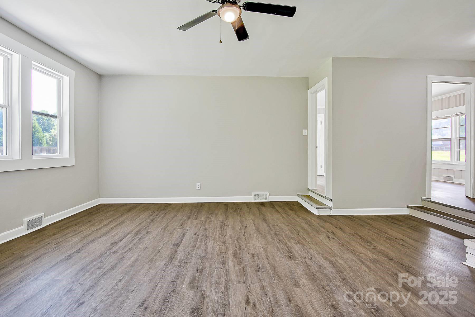 1435 West Ridge Road Salisbury, NC 28147 - Photo 20 of 48 an empty room with wooden floor fan and windows