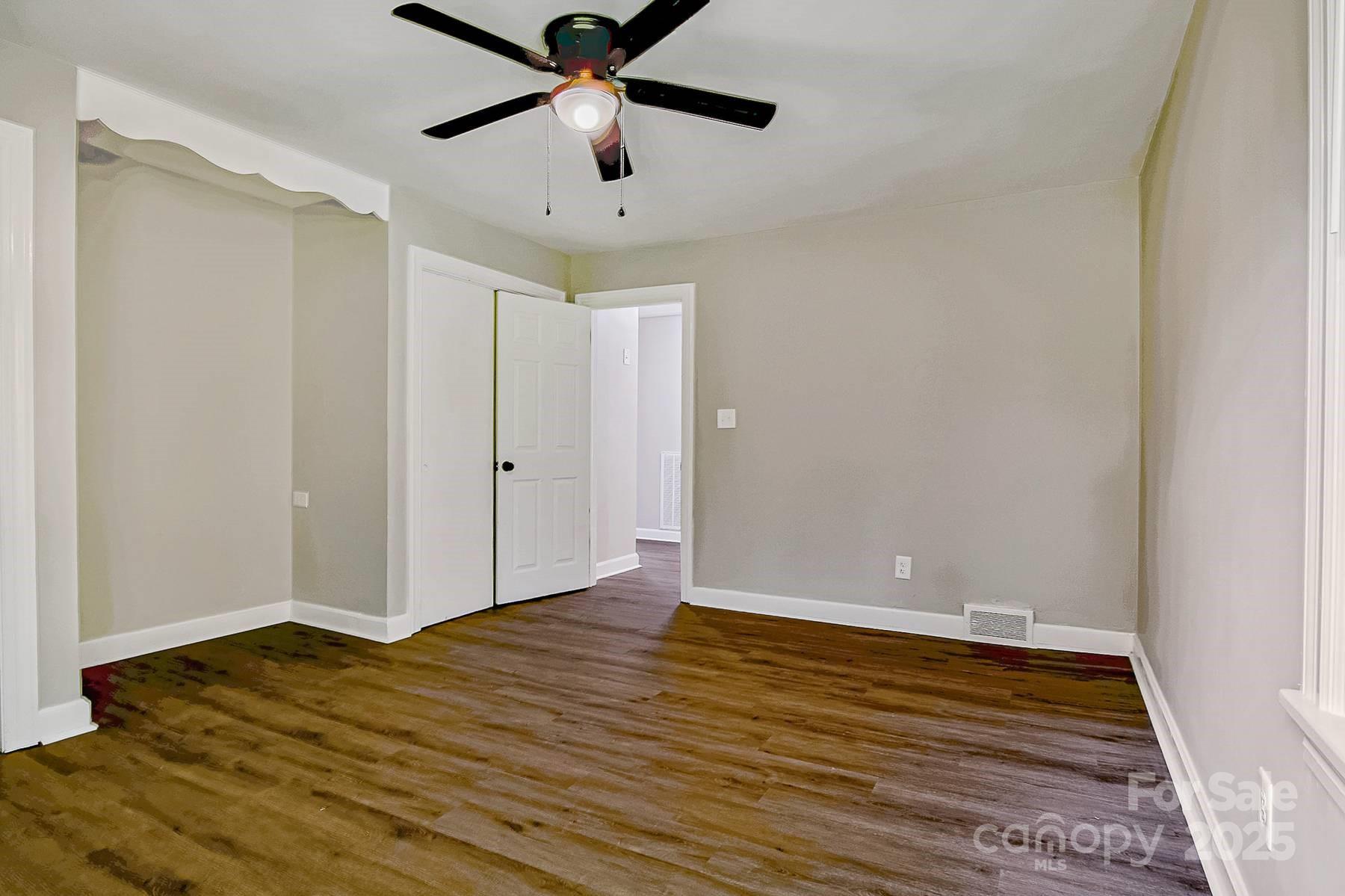 1435 West Ridge Road Salisbury, NC 28147 - Photo 36 of 48 an empty room with wooden floor and a ceiling fan
