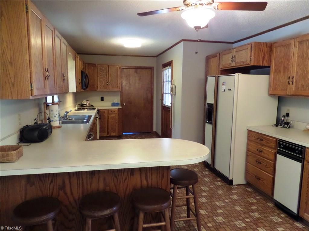 3308 Doub Road East Bend, NC 27018 - Photo 11 of 27 Breakfast bar provides counter space and is great for a quick meal. Notice the ceiling fan too. The door ahead is a large laundry room. Door on the right leads to the garage.