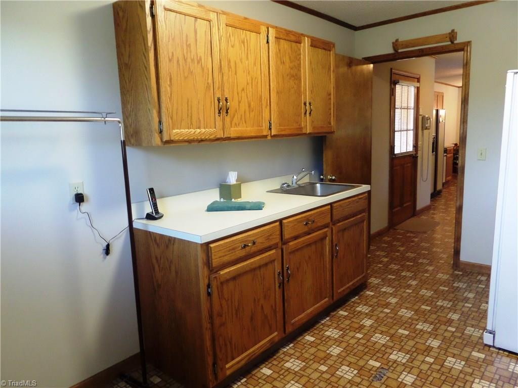 3308 Doub Road East Bend, NC 27018 - Photo 15 of 27 Laundry room has cabinetry, sink and room for hanging space.
