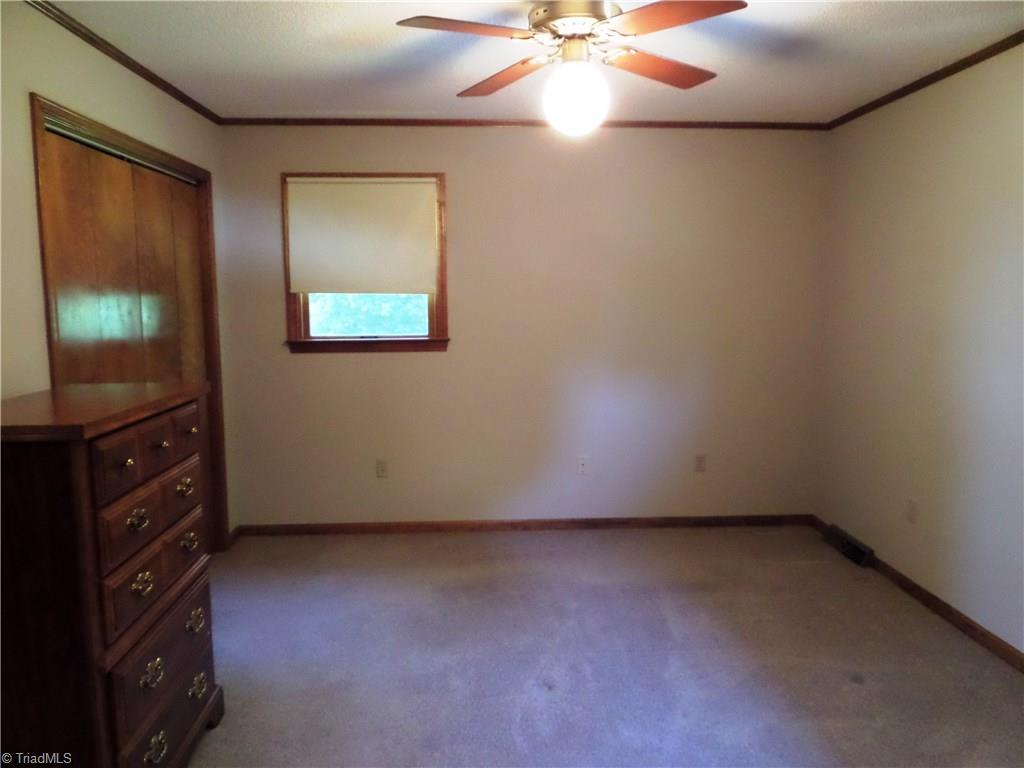 3308 Doub Road East Bend, NC 27018 - Photo 19 of 27 Master bedroom has crown molding, ceiling fan, double closet and a private bathroom.