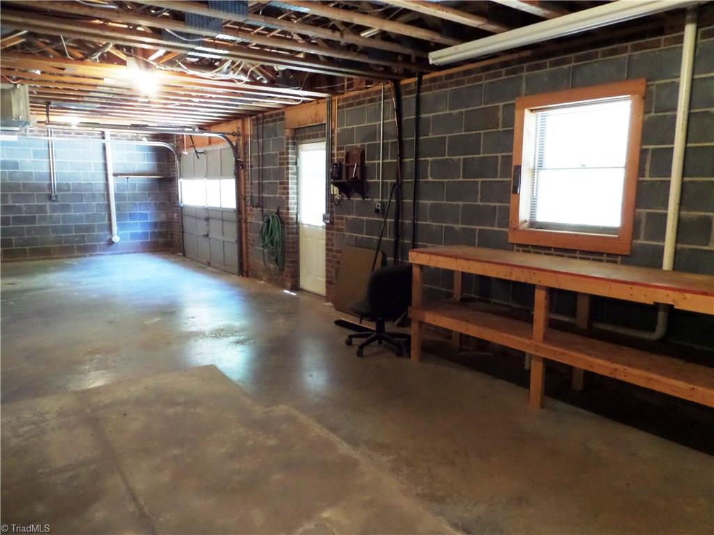3308 Doub Road East Bend, NC 27018 - Photo 24 of 27 Workbench or more shelving for storage. There is a walk out door to the back of the house and garage space with a garage door opener.