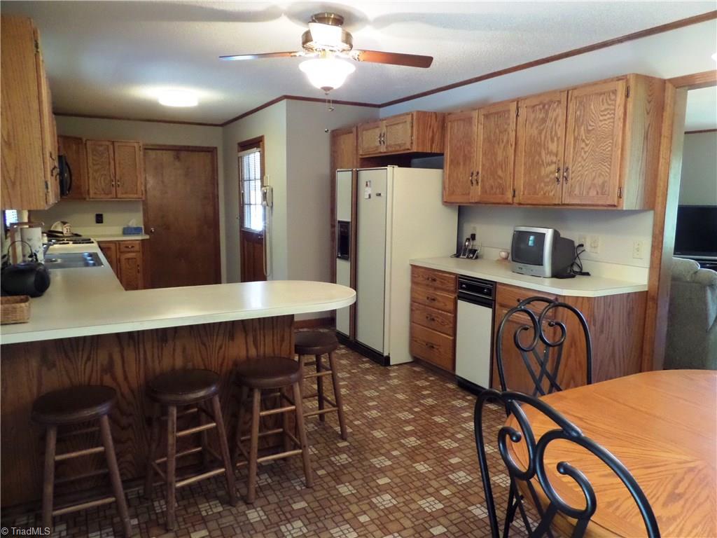 3308 Doub Road East Bend, NC 27018 - Photo 10 of 27 Large kitchen with an abundance of cabinet space. This view shows the refrigerator and trash compactor. There is a pantry cabinet to the left of the refrigerator with roll out shelves.