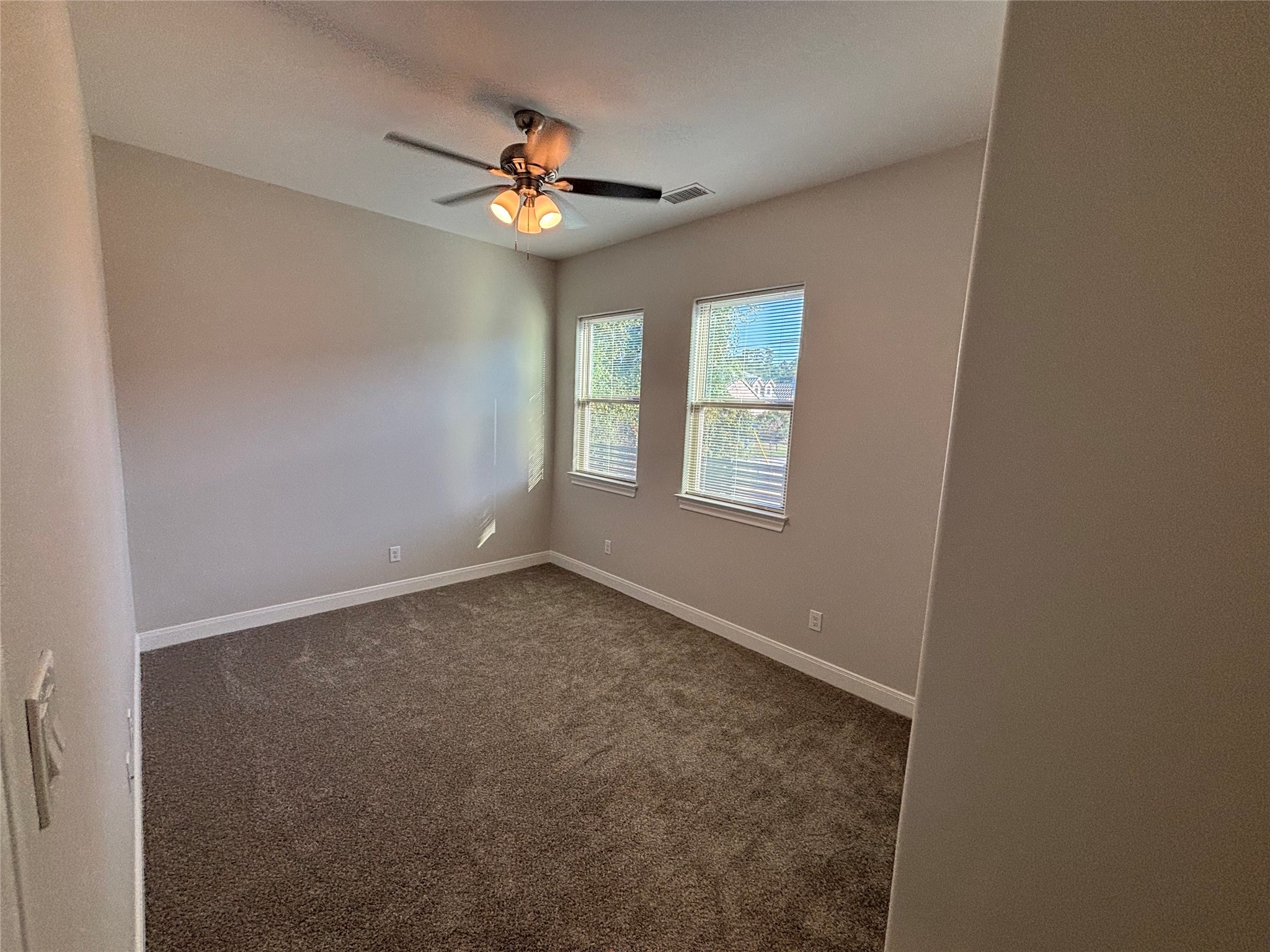 504 Nursery Road, Unit 1209 The Woodlands, TX 77380 - Photo 24 of 27 an empty room with windows and chandelier fan
